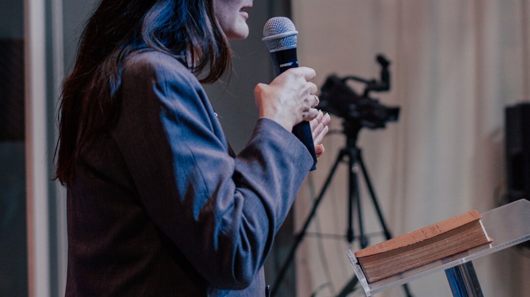 TV presenter speaking confidently on a modern set with teleprompter